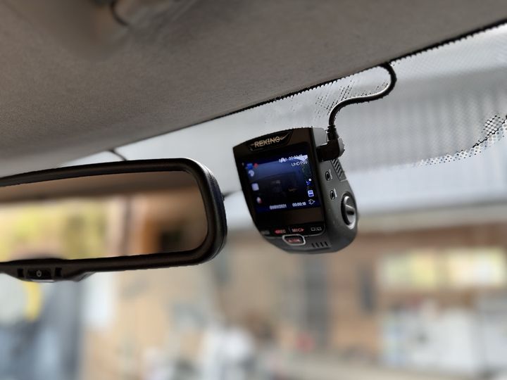 Front-facing dash camera mounted on the windscreen beside the rear-view mirror