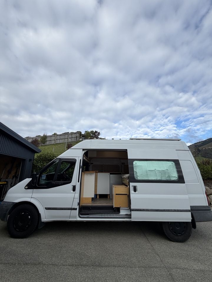 Full side profile of the high-roof Transit with the sliding door open
