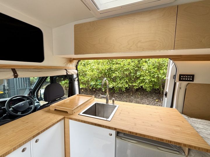 Bamboo counter with a stainless sink, tap and chopping board
